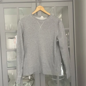 Grå sweatshirt - Säljer en stilren grå sweatshirt med rund hals och långa ärmar. Perfekt för en avslappnad look. Tröjan har ribbade muddar vid ärmslut och nederkant för extra komfort.