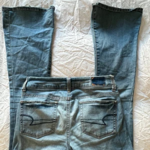 Lågmidjade bootcut jeans - Snygga blå jeans från American Eagle med måg midja och bootcut modell. Perfekta för en avslappnad stil. Midjemåttet är 37cm och skriv gärna om ni har några frågor💕💕