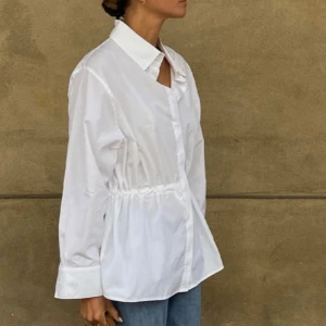 Vit skjorta från Stylein - Skjorta från Stylein med långa ärmar och knappar framtill. Knytning i midjan som går att justeras hur man vill.  Hittar inget att anmärka på. Storlek: XS, normal i storlek Material: 100% bomull Skick: Mycket bra