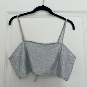 Glittrig mini topp - Säljer denna silverglittriga toppen som är helt oanvänd och har prislappen kvar