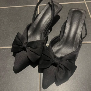 Svarta pumps med rosett - Eleganta svarta pumps med spetsig tå och rosett framtill