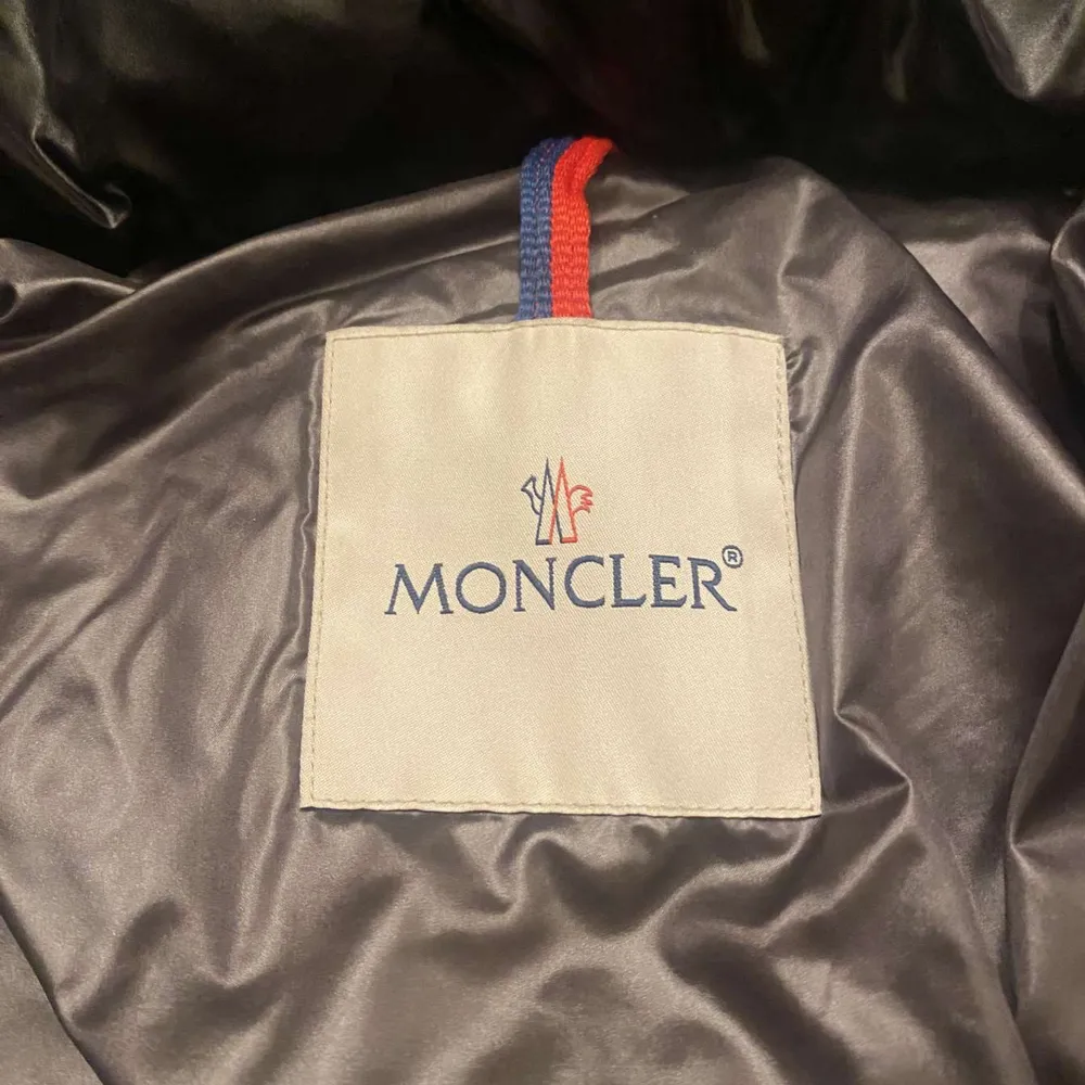 Säljer en snygg svart dunjacka från Moncler med huva och dragkedja. Jackan har en quiltad design och två fickor med dragkedjor. Perfekt för kalla dagar!. Takit.
