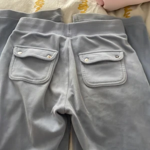 Ljusblå mjukisbyxor från Juicy Couture - Säljer ett par ljusblå mjukisbyxor från Juicy Couture. Byxorna har snörning i midjan. Perfekta för en avslappnad stil.