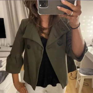 Trekvartsärmad kappa zara - Säljer denna grön/bruna kappa från zara! Den är i bra skick förutom att det saknas en knapp! (Sista bilden)💗 Det är lånade bilder❤️Den är i storlek L men sitter som en S