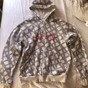 Vit och svart mönstrad Billabong hoodie - Säljer en cool vit hoodie med svart mönster och röd broderad text från Billabong. Skulle säga det är strl XL.