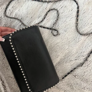 Svart axelväska med silverdetaljer - Svart, liten men väldigt rymlig väska till sommaren🌸Använd ca 2 gånger så nyskick, inga defekter!