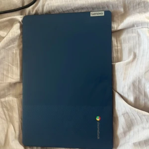 Blå Lenovo Chromebook med laddare - Säljer en stilren blå Lenovo Chromebook med tillhörande laddare. Datorn har USB-portar, hörlursuttag och minneskortläsare. Tangentbordet är svart med vita tecken och skärmen har färgglad bakgrund. Perfekt för studier eller surf. Nypris 2990 kr