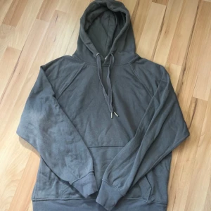 Grå/blå hoodie från Divided - Mysig grå/blå hoodie från h&m Divided med huva och dragsko. Tröjan har långa ärmar och en klassisk passform. .