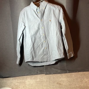 Ljusblå skjorta från Polo Ralph Lauren - Klassisk ljusblå skjorta från Polo Ralph Lauren. Skick 8/10! Storlek 10-12 år. Passar om du är runt 140-150 cm!