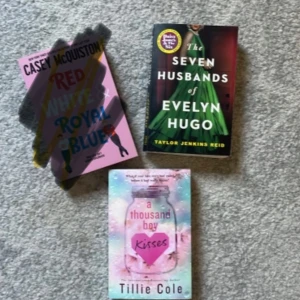  The Seven Husbands of Evelyn Hugo, A thousand boy kisses - Tre populära böcker: 'Red, White & Royal Blue' av Casey McQuiston med rosa omslag, 'The Seven Husbands of Evelyn Hugo' av Taylor Jenkins Reid med grönt och svart omslag, samt 'a thousand boy kisses' av Tillie Cole med pastellfärgat omslag och hjärtdetaljer. 1 bok för 40kr