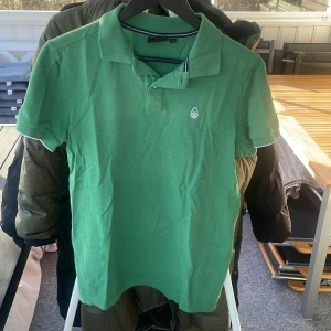 Grön pikétröja från Sail Racing - Säljer en grön pikétröja från Sail Racing med klassisk krage, har växt ur den.