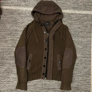 Unik stickad cardigan / kofta - Riktigt snygg och stilren cardigan / kofta i en fin brun färg. Zip och knappar✅Bra skick. Storlek L. Går inte att köpa längre. Skriv vid minsta intresse, pris går alltid att diskutera vid smidig affär😀