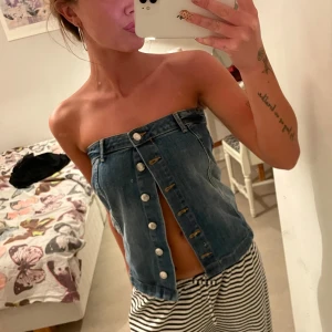 Jeanstopp med knappar framtill - Säljer en klassisk blå jeantppp från Gina Tricot med knappar hela vägen framtill och bälteshällor. 