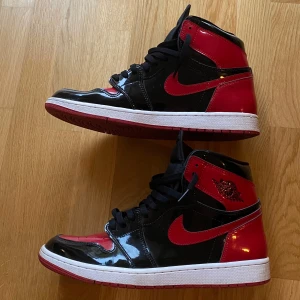  Jordan 1 Retro High OG ”Bred Patent” - Säljer mina breds då jag knappt använder de, de sparsamt använda(10 gånger” jättesnygga skor som passar till alla stilar. Till mjukis till jeans tillochmed till kostymbyxor  finns kvitto