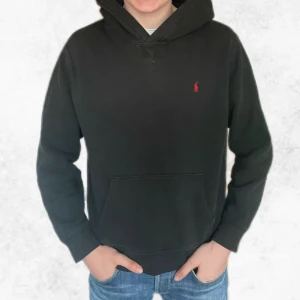 Svart hoodie från Polo Ralph Lauren - Klassisk svart hoodie från Polo Ralph Lauren med liten röd logga broderad på bröstet. Det är storlek (18-20) vilket motsvarar ungefär S i herr storlekar.