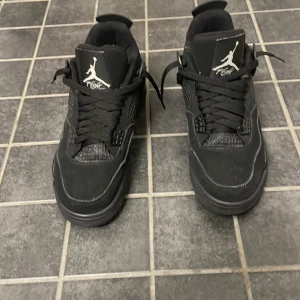 SÄLJER AIR JORDAN 4 BLACK CATS - Säljer ett par helsvarta Nike Air Jordans sneakers med klassisk siluett och Jumpman-logga på plös och häl. Skorna har snörning, rund tå och platt sula. Perfekta för dig som gillar streetwear och vill ha en stilren look. Pris kan diskuteras 