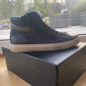 Svarta sneakers från Crime London  - Säljer ett par svarta höga sneakers från Crime London med snörning och dragkedja på sidorna. Köpte dessa skor i december 2024 och har bara använts från då till februari. Skorna är lite smutsiga men kan tvätta dem vid önskan! Jag köpte skorna från deras egna hemsida och det var då vinter rea då jag köpte dem. Org pris 1600 köpte dem för 1100kr. Priset kan diskuteras!🙂 