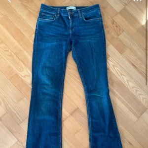 Blå bootcut jeans från Zara - Säljer ett par klassiska blå bootcut jeans från Zara. Jeansen har normal passform, fem fickor och stängs med dragkedja och knapp. Perfekta till vardags och lätta att matcha med olika toppar.