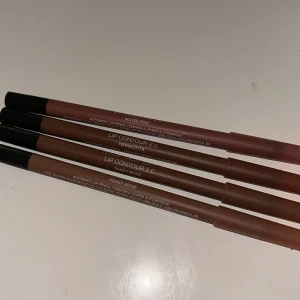 HUDA BEAUTY LÄPPPENNOR - Säljer fyra läppennor i olika nude- och rosa toner: muted pink, terracotta, sandy beige och honey beige. Pennorna är smala och automatiska, perfekta för att definiera läppkonturen och skapa en naturlig look.