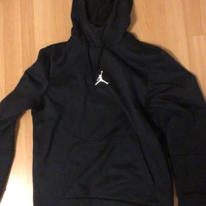 Svart hoodie från Jordan - Säljer en snygg svart hoodie från Jordan med den klassiska Jumpman-loggan på bröstet. Den är i storlek  S och har en skön standard. fit. Perfekt för både vardag och träning. Justerbar med snören och materialet är mjukt och bekvämt. Knappast använd.