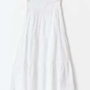 Vit långkjolfrån Gina Tricot - Säljer en vit långkjol från Gina Tricot med smock upptill och volangiga lager nedtill. Kjolen är luftig och perfekt för somriga speciella tillfällen.