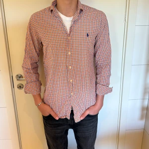 Ralph Lauren skjorta  - Säljer en klassisk rutig skjorta från Polo Ralph Lauren i orange, blått och vitt. Perfekt för dig som gillar stilrena och tidlösa plagg. Storlek M