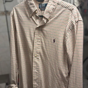 Rutig skjorta från Polo Ralph Lauren - Klassisk  skjorta från Polo Ralph Lauren. Skjortan har lång ärm, knappar framtill och broderad logga på bröstet. Perfekt för en stilren och tidlös look.