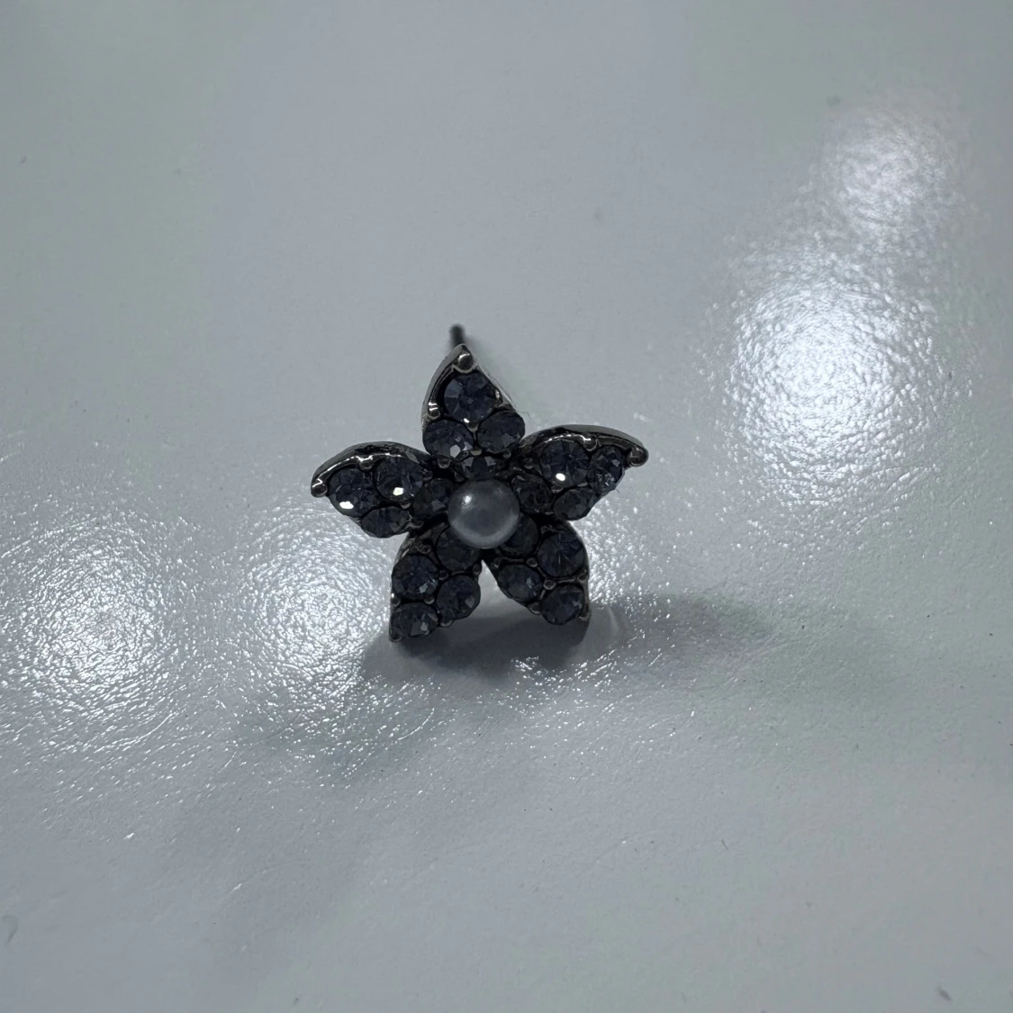 Blomformad örhänge med svarta stenar och pärla