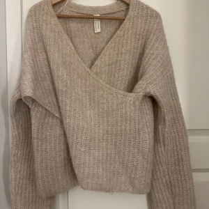 Beige stickad omlott-tröja  - Mysig beige stickad tröja med omlott-design.