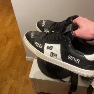 Svarta och vita sneakers från Valentino - Säljer ett par svarta och vita Valentino sneakers med textdetaljer på sidorna och cool sula med camouflage-mönster. Skorna har svarta skosnören, rund tå och platt sula. Perfekta för dig som vill sticka ut med din stil. Sköna, knappt använda och sitter super. Hör av dig om du har frågor. PRISET KAN DISKUTERAS.