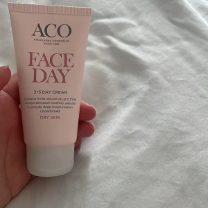 ACO Face Day 3+3 Day Cream - En ljusrosa tub med ACO Face Day 3+3 Day Cream för torr hud. Innehåller tre naturliga oljor och tre fuktgivare för djup återfuktning. Oparfymerad och passar för daglig användning.