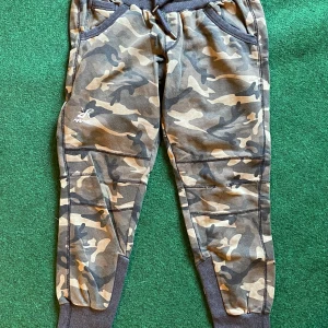 Camo Cozy Pants från RVRC  - Snygga camouflagemönstrade mjukisbyxor från RVRC i storlek XL/42. Byxorna har ribbade muddar, snörning i midjan och praktiska fickor. Perfekta för chill dagar eller när du vill ha en avslappnad stil.