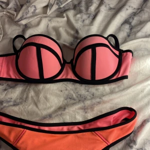 2016 neon Rosa  bikini med svarta kanter - Snygg bikini i rosa o med svarta kontrastkanter. Bh-n är storlek 75c typ och trosorna är M Överdelen har bygel och vadderade kupor med coola svarta linjer, och underdelen är enkel med samma färgtema. Perfekt för stranden eller poolen, ger en riktigt trendig look. HAR ENDAST ANVÖNDT EN GÅNG SEN JAG KÖPTE DEM OCH DET VAR NÄR JAG SKULLE PROVA DEM 