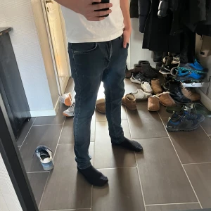 Nudie jeans - Säljer mörkblå Nudie jeans dom sitter slim och är i bra skick förutom slitning vid grenen. Mitt pris är 250kr det är bara höra av dig vid minsta fundering. Storleken är W28 L30