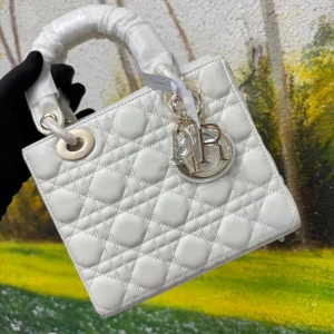 Vit quiltad Lady Dior handväska - Superfin Lady Dior handväska i vit quiltad skinn med ikoniska Dior-hängen i silver. Klassisk boxig form med två handtag och snygga detaljer i metall. Perfekt för dig som vill ha en lyxig och tidlös accessoar med exklusiv känsla.