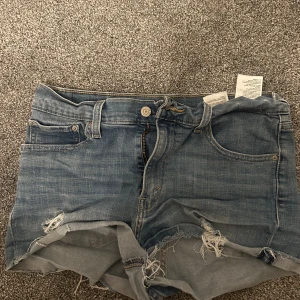 Levis jeansshorts - Jeansshorts från Levis med lite slitningar! Så snygga, ett måste till sommaren!! Storlek W30 men passar mig som har xs/s jättebra om man sätter de lite längre med👌🏽👌🏽