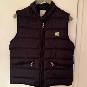 Moncler gui vest  - Säljer nu denna fina Moncler väst i strl:3. Västen är i väldigt fint skick och såklart äkta (kvitto finns)! Hör av er vid minsta lilla fråga! 
