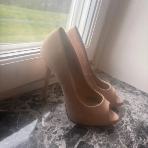 Beiga pumps med öppen tå, ASOS - Snygga pumps i beige med hög klack och öppen tå, köpta på asos men andvänd fåtal gånger då de vart för stora för mig, hoppas någon annan kan ge dessa skor en andra chans🌸👠