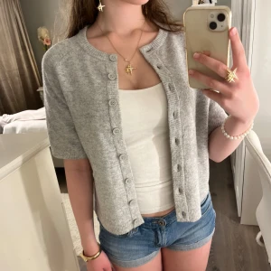 Grå kortärmad kofta från Nelly - Superfin mjuk grå kortärmad kofta från Nelly i storlek xs. Endast använd en gång💗           Nypris: 350 kr