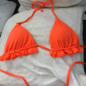 Orange ribbad bikini  - Superfin orange bikini ribbad. Överdelen är en triangelmodell med knyt i nacken och i bak. Aldrig använd. överdelen är S och underdelen är M.