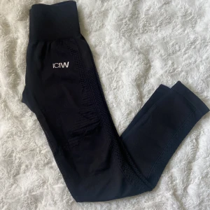 Svarta seamless tights från ICANIWILL - Svarta seamless tights från ICANIWILL med hög midja och ribbade detaljer. Perfekta för träning och har snygg struktur längs benen för extra stilpoäng. Säljer pga att de aldrig kommer till användning.