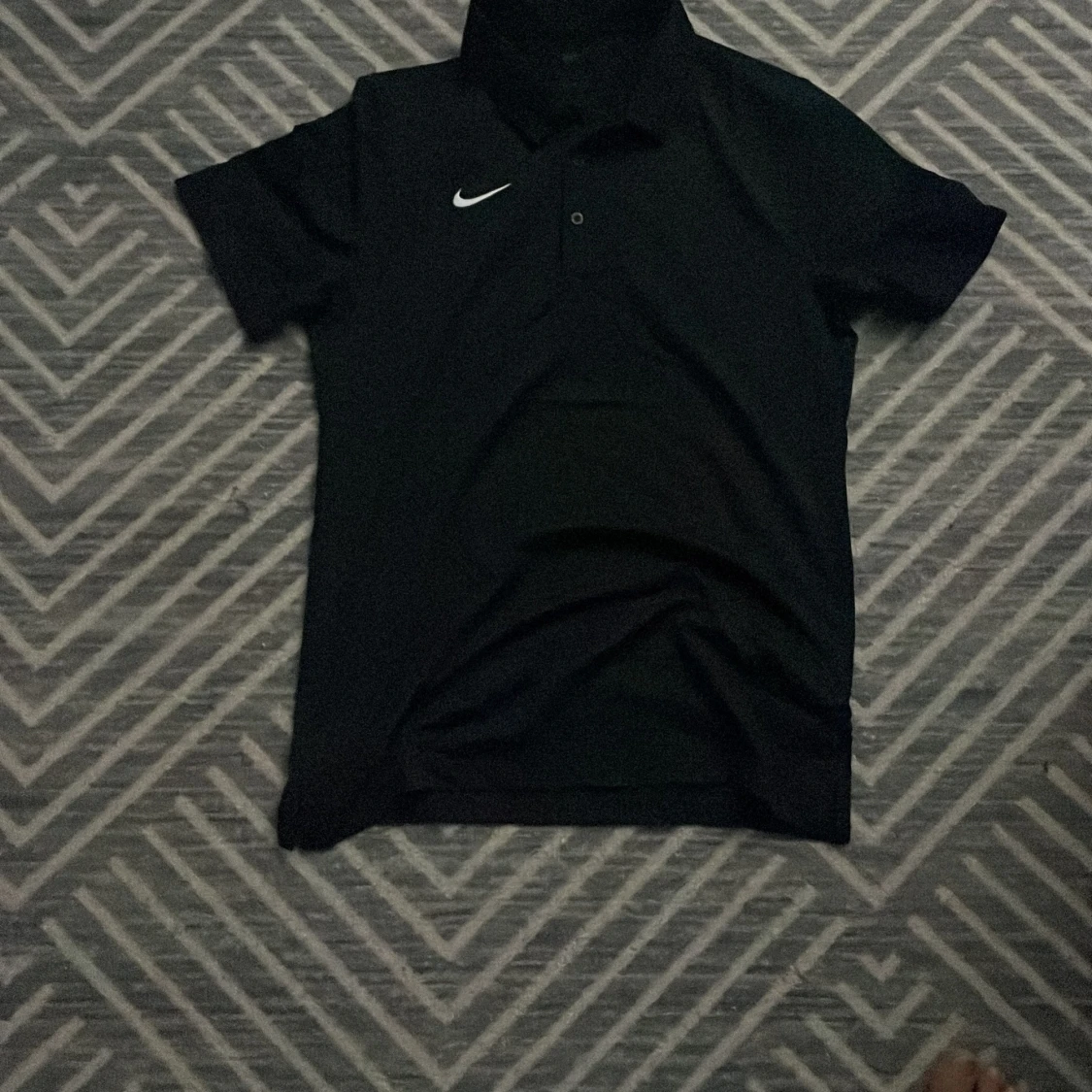 Svart pikétröja från Nike i S