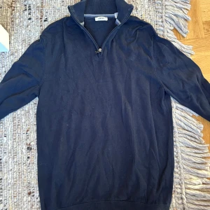 Mörkblå half zip tröja från Esprit - Mörkblå långärmad tröja från Esprit med hög krage och half zip-dragkedja. Tröjan är i mjuk bomull och har ribbade muddar vid ärmslut och nederkant. Perfekt för lager-på-lager och chill stil.