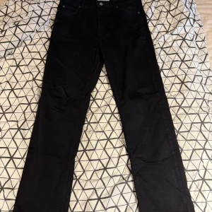 Svarta jeans från Just Junkies - Säljer ett par svarta jeans från Just Junkies i modellen Curtis. Byxorna är i stretchigt material med 98% bomull och 2% elastan, vilket gör dem riktigt sköna och följsamma. Klassisk femficksdesign och snygg, stilren look.