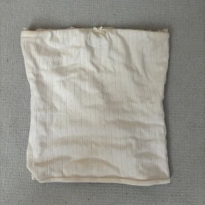 Vit bandeau tubtopp från Bikbok  - Söt vit bandeau tubtopp från Bikbok i storlek XS. Toppen har diskreta ränder och små hålmönster, samt spetsdetaljer längs överkanten. Perfekt för en fräsch och somrig look!