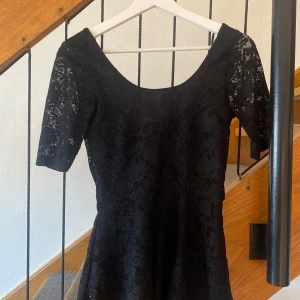 Svart spets topp från Gina Tricot💕 - Supersöt svart topp från Gina Tricot i spets med blommigt mönster. Toppen har korta ärmar, rundad urringning och sitter figurnära upptill. Men också lite öppen i ryggen💕. Säljer då den aldrig kommer till användning💕 använd 1 gång!!