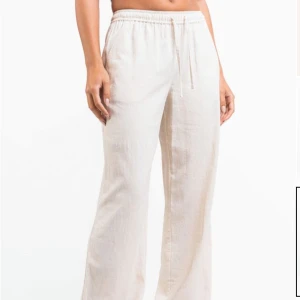 Beiga linnebyxor med snörning från Madlady - Snygga beiga linnebyxor med rak och loose passform från Madlady. Byxorna har elastisk midja med snörning och sidofickor. Perfekta för chill dagar eller när du vill ha en avslappnad look. Lätta och luftiga i materialet, passar grymt till sommaren. I helt oöppnad förpackning så är aldrig använda. I regular längd🩷