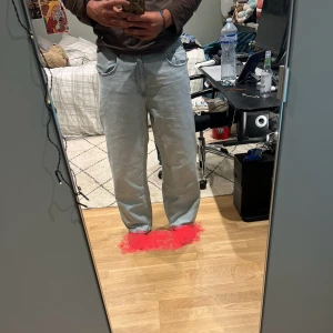 Ljusblå raka jeans i loose fit - Säljer ett par ljusblå jeans med raka ben och loose fit. Klassisk femficksmodell med bälteshällor och knappgylf. Jeansen har en avslappnad vibe och är perfekta för dig som gillar en chill och enkel stil.