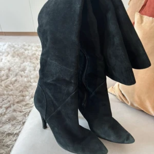 Svarta mockastövlar  - Snygga svarta stövlar i mocka med spetsig tå och klack. Stövlarna är slouchy och kan gå upp över knäet eller tryckas ner under knäet. Står ingen storlek men lite små på mig som är 38 så gissar 37