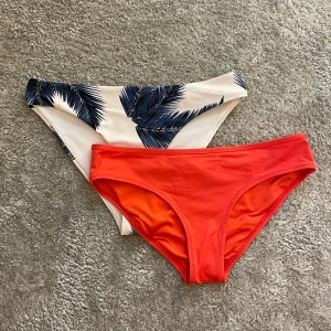 Två bikiniunderdelar Calvin Klein & mönstrad - Säljer två snygga bikiniunderdelar. Ena är koralorange från Calvin Klein med klassisk passform och mjukt syntetmaterial. Den andra är vit med marinblå palmbladsmönster, också i stretchigt syntet. Perfekta för stranden eller poolen i sommar! Båda för 40kr